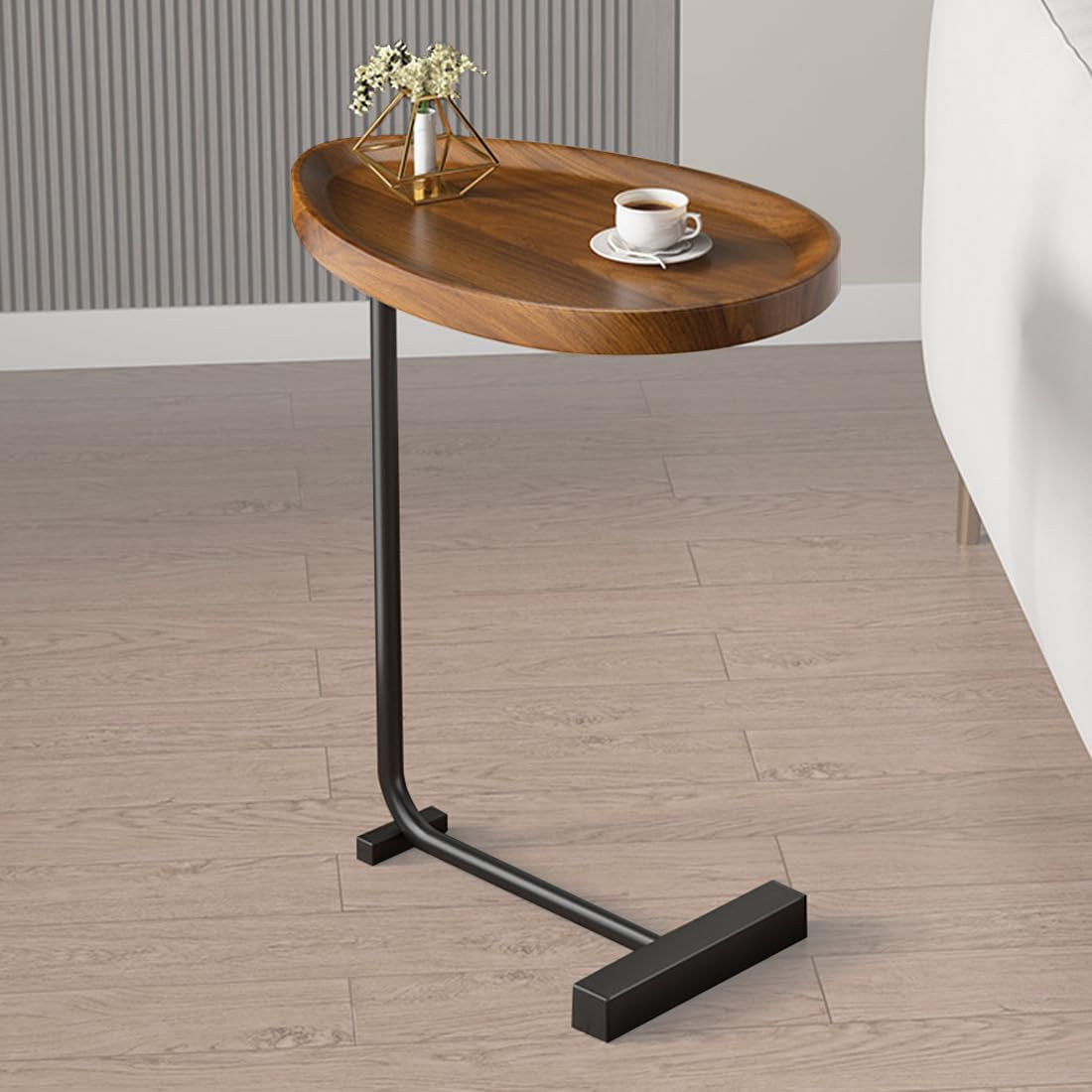 Wooden side table with black metal leg on a wooden floor