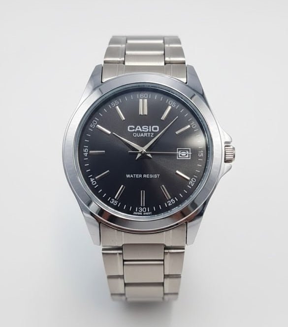 Casio watch with black dial and silver metal strap on a white background