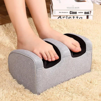 Gray footrest being used with a person's feet on a beige carpet